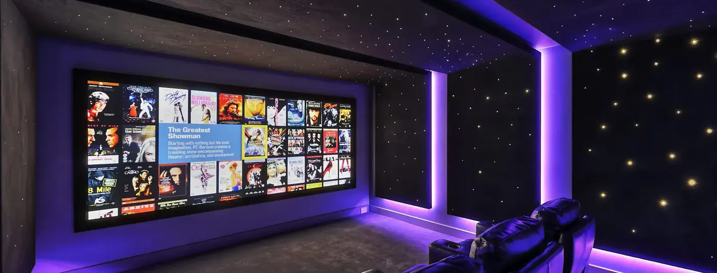 Sala de cinema dedicada com teto de estrelas, tela ampla e poltronas reclináveis