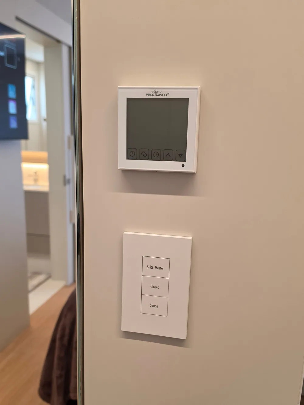 Termostato Álamo Piso Térmico e keypad de zonas (Suíte Master, Closet, Sanca) na parede da suíte